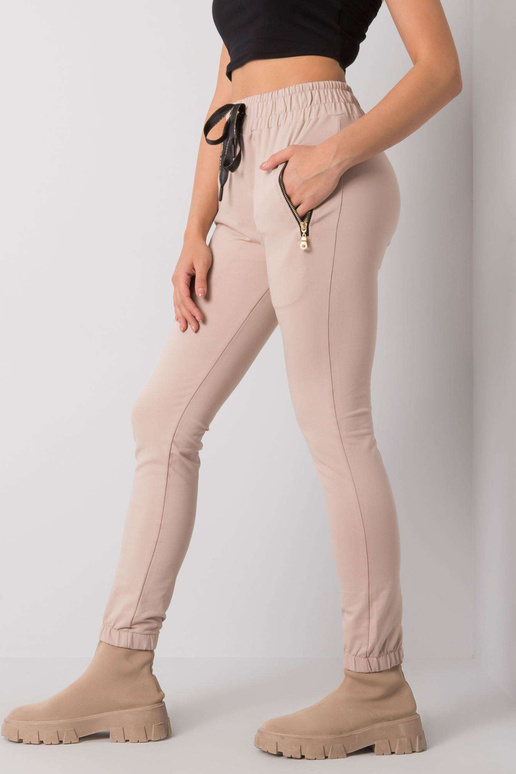 Gaiši bēšas treniņbikses ar kabatām...