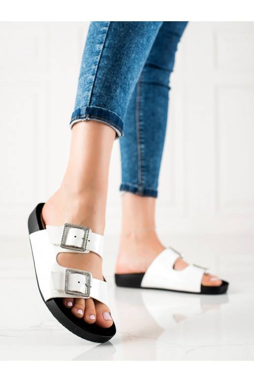 baltas krāsas klapki z ozdobnymi sprzączkami